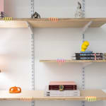shelves with assorted books, sculptures, and lamp