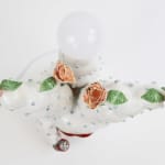Cactus like sculpture with large red lips and roses on the end of the branches holding a ketchup bottle