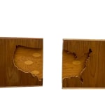 Wooden silhouette of the United States surrounded by darker wood cut in half and hung as saloon doors