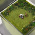 Aerial view of a miniature sculpture of two poodles eating a body by artist Abigail Goldman