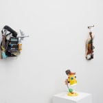 white wall with three different sculptures displayed