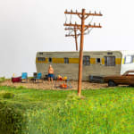 miniature diorama by Abigail Goldman of woman being roasted over an open flame in front of an RV