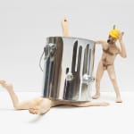 sculpture of nude anthropomorphic dog crushed under a silver paint can and another dog watching