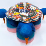 Sculpture of three blue birds holding a plate of food and various things on their backs