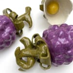 Sculptures of two purple berries and a white flower