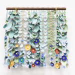 ceramic sculpture made up of dangling individual components that resemble leaves and flowers by artist Anastasia Tumanova