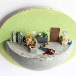 miniature diorama by Abigail Goldman of two people having sex in an office next to someone bleeding out