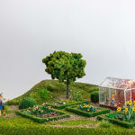 miniature diorama by Abigail Goldman of a person gardening and a dead body in their green house