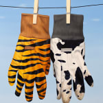 Two gloves hanging on the clothes line, one with a cow print and the other with Tiger print