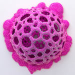 Sculpture by Dan Lam of a drippy sphere covered in tiny spikes with small holes in broken out of it