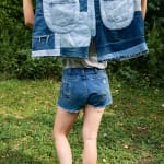 Artist Natalie Baxter holding oversized patchwork denim jorts outdoors while wearing jorts