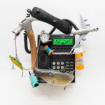 sculpture of black phone with random objects attached