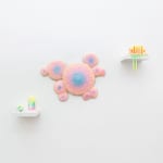 Installation shot of a sculpture with multiple circular objects with a pink to purple gradient by Dan Lam.