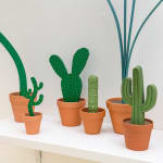 Jeff Canham wooden plant sculptures in a terra cotta pots - In a cluster on a shelf