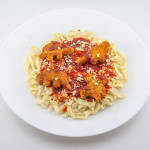 Glass sculpture of a white plate with spaghetti topped with dino nuggets