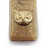 rectangular gold cosmetic compact with large owl face and engraving