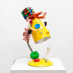 yellow lamp with dog facial features with various items stacked on top also with dog faces