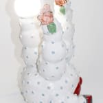 Cactus like sculpture with large red lips and roses on the end of the branches holding a ketchup bottle