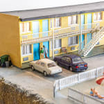 miniature diorama by Abigail Goldman of a woman bleeding on the ground in the parking lot of a motel