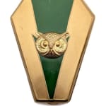 gold compact with green triangle down the center and gold owl