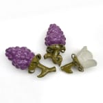 Sculptures of two purple berries and a white flower