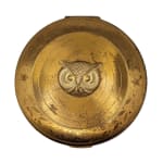 gold cosmetic compact with gold owl face in the center