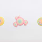 Installation shot of circular sculpture by Dan Lam with pink and purple circles and tiny bright yellow spikes