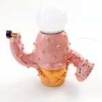 Lamp sculpture of a cactus like object with lips and two arms holding a plate with a sandwich and the other a bag of chips