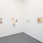white gallery wall with small assorted artworks