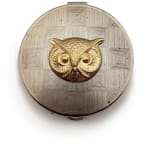 Silver circular cosmetic case with owl face in the center