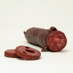 Stephen Morris "Salami" ceramic sculpture of realistic red salami with two pieces cut out revealing a face