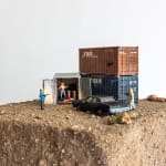 Abigail Goldman diorama of two men pointing guns at two people in shipping containers