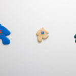white wall with colorful wooden figures by Jocelyn Tsaih