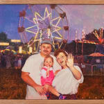 painting of a family in front of a ferris wheel with a sunset background by Pat Perry