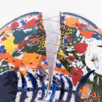Sculpture of three blue birds holding a plate of food and various things on their backs