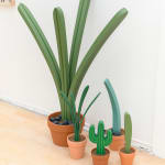 Jeff Canham wooden plant sculpture in a terra cotta pot - in a cluster on the floor