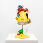 yellow lamp with dog facial features with various items stacked on top also with dog faces