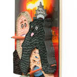 Mixed media hanging sculpture of a woman with a carrot in her mouth holding a small black dog with a Happy New Year paper crown on his head and a pretzel and a carrot in his hands. In the background an atomic bomb is going off.