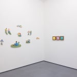 White gallery wall with various pieces by Danym Kwon including paintings and small wooden sculptures