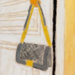 grey bag with gold accents hanging on doorknob of a white door