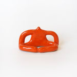 ceramic piece by Jocelyn Tsaih of an orange figure sitting