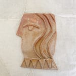 brown side profile of a face made from ceramic clay