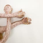 detail shot of sculpture by Jen Dwyer of light pink tentacle like objects emerging from brown mound with green leafs