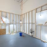 wooden scaffolding on whit ewalls with dog human sculptures displayed around the room