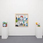 white wall with a painting in the middle and sculptures on either side