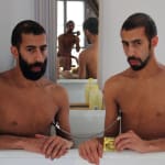 Photograph of two shirtless men in a bathtub