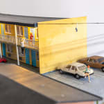 miniature diorama by Abigail Goldman of a woman bleeding on the ground in the parking lot of a motel
