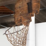 Sculpture of a broken basketball hoop made from found wood branches and wisteria seed pods