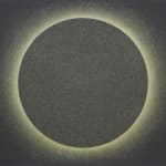 A greenish sphere is backlit by a neon yellow halo on a black horizontal rectangular background.