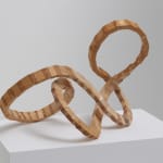 Wooden sculpture composed of small thin plywood planks layered and joined together in a way that creates an image similar to that of a crumpled rubber band